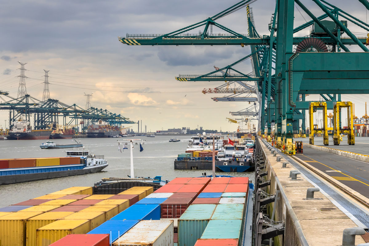 Loaded ships in busy container terminal with automated cranes and lots of vessels