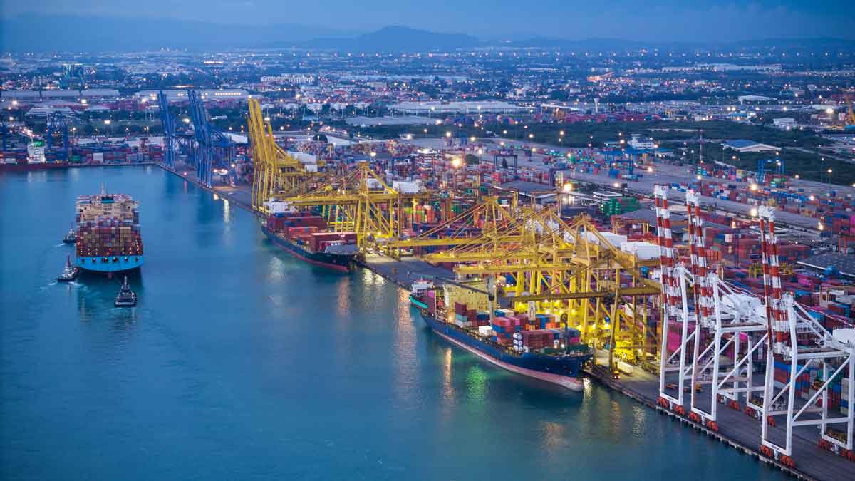 crane loading cargo container from truck to container ship in the international terminal