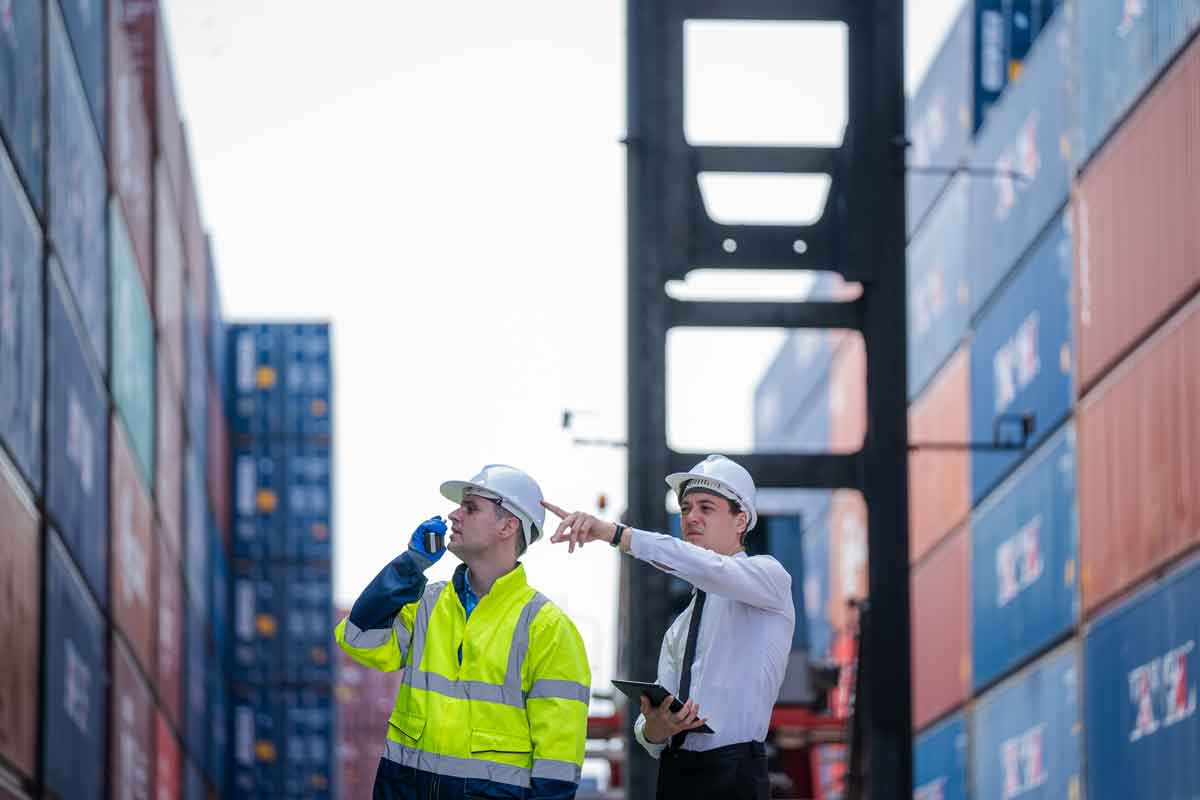 two men checking containers at container yard warehouse